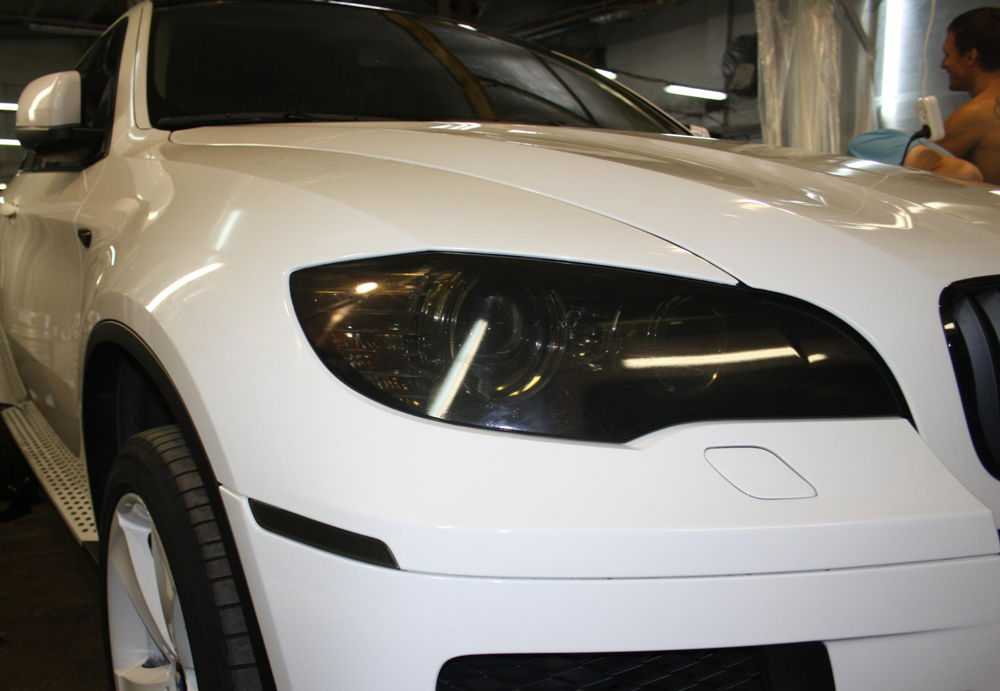 Белая BMW X6 с тонированными фарами